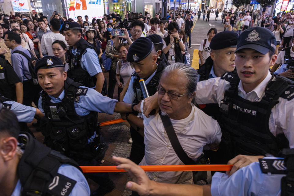 A member of the public is taken away by the police in the Causeway Bay area on the eve 34th anniversary of China's Tiananmen Square massacre in Hong Kong, Saturday, June 3, 2023. (AP Photo/Louise Delmotte)