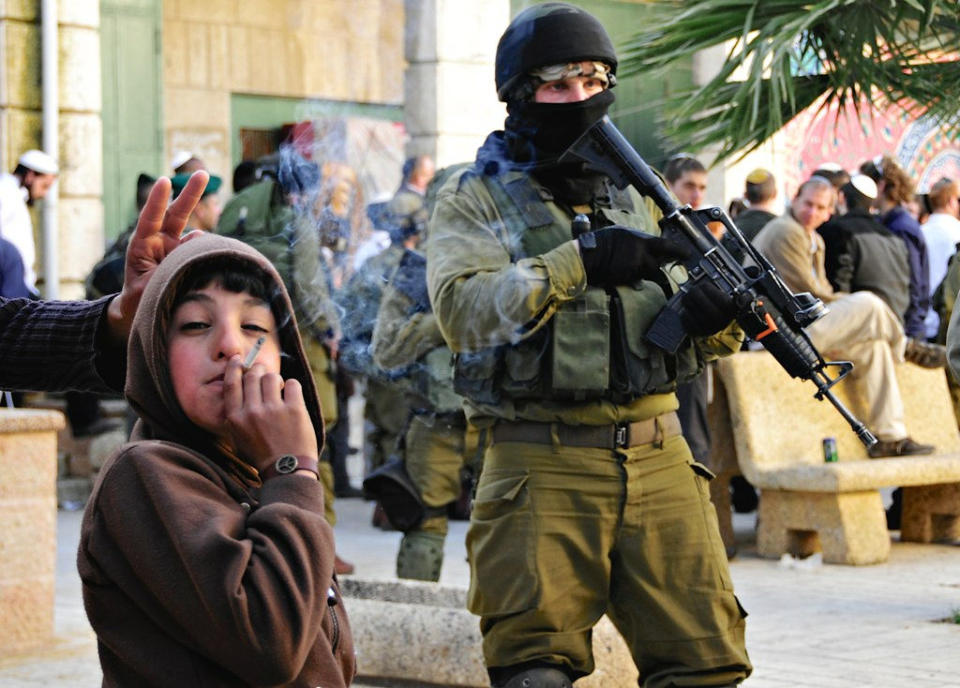 I noticed this kid wearing a bracelet with a peace sign on amidst the chaos. By: M. Khatib