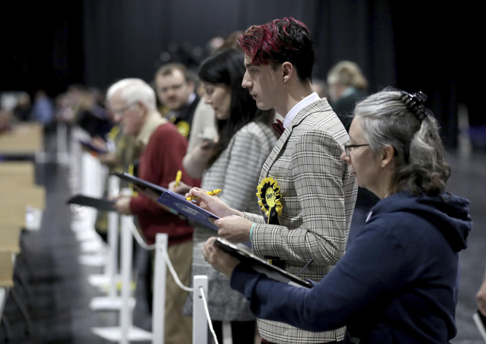 Election agents watch as ballot papers are counted at the SEC Centre in Glasgow, Scotland Thursday Dec. 12, 2019. An exit poll in Britain’s election projects that Prime Minister Boris Johnson’s Conservative Party likely will win a majority of seats in Parliament. That outcome would allow Johnson to fulfil his plan to take the U.K. out of the European Union next month. (Andrew Milligan/PA via AP)