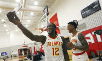 Atlanta Hawks forward Taurean Prince (12) takes a photo of himself and and forward John Collins (20) during their NBA basketball media day Monday, Sept. 24, 2018, in Atlanta. (AP Photo/John Bazemore)