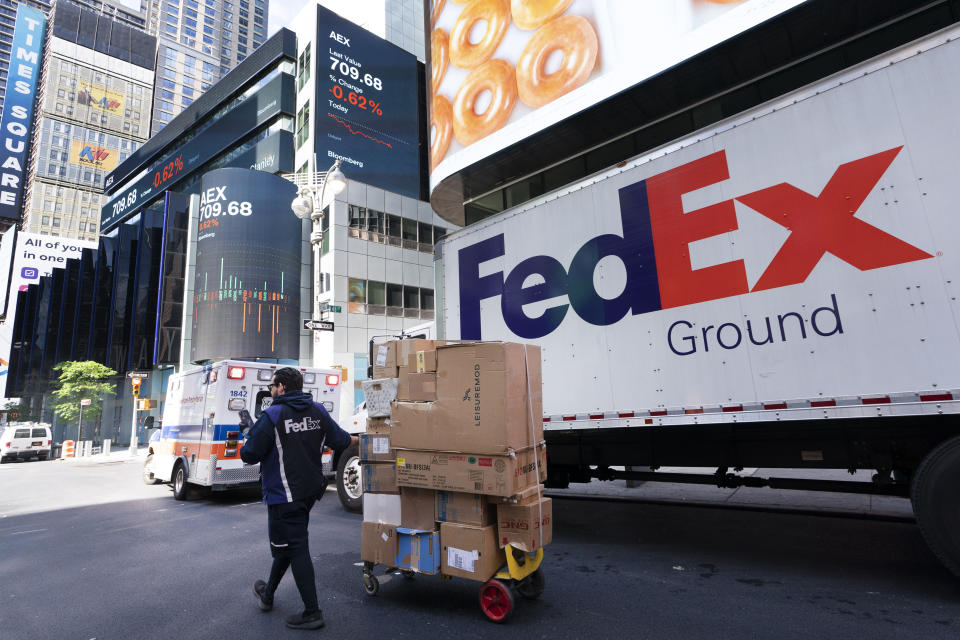 A FedEx driver delivers a cart of packages, Thursday, May 6, 2021, in New York. FedEx is getting hurt by the tight job market. The package delivery company said Tuesday, Sept. 21 that its costs are up $450 million in the most recent quarter, as it paid higher wages as it got harder to find new workers and demand for shipping increased. (AP Photo/Mark Lennihan)