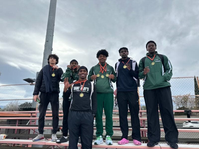 Members of St. Mary's high school boys' track and field team pose for a photo while showing off medals they won during a track meet in the 2023-24 season.