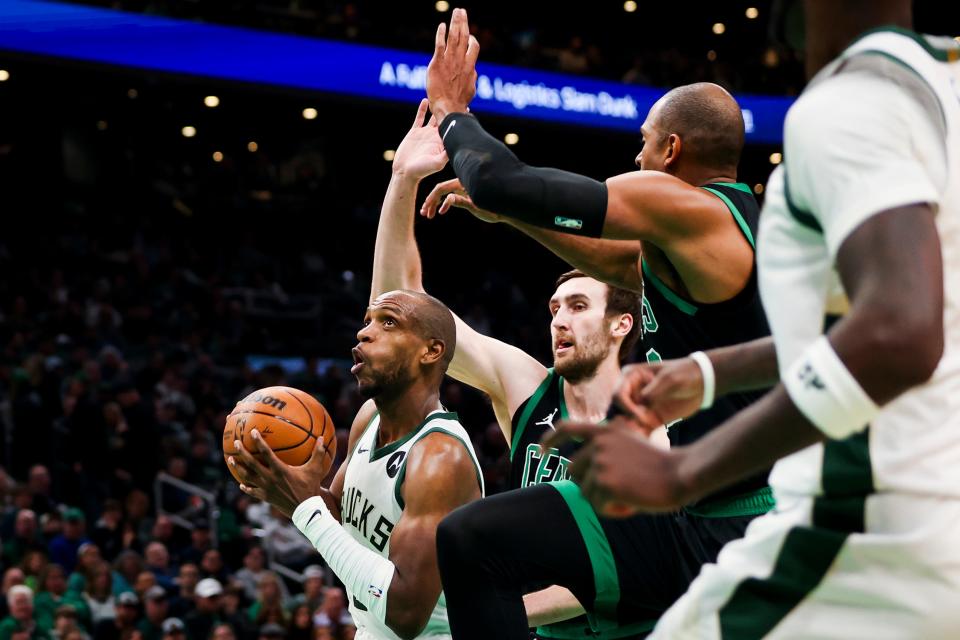 Bucks forward Khris Middleton gets past a pair of Celtics on a drive to the basket during the first half Wednesday at TD Garden.