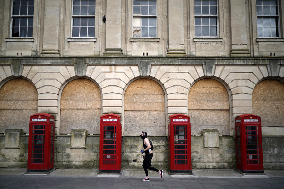 BLACKPOOL, ENGLAND - APRIL 02: A man wearing a mask jogs past iconic red phone booths, amid the coronavirus lockdown. (Photo by Christopher Furlong/Getty Images)