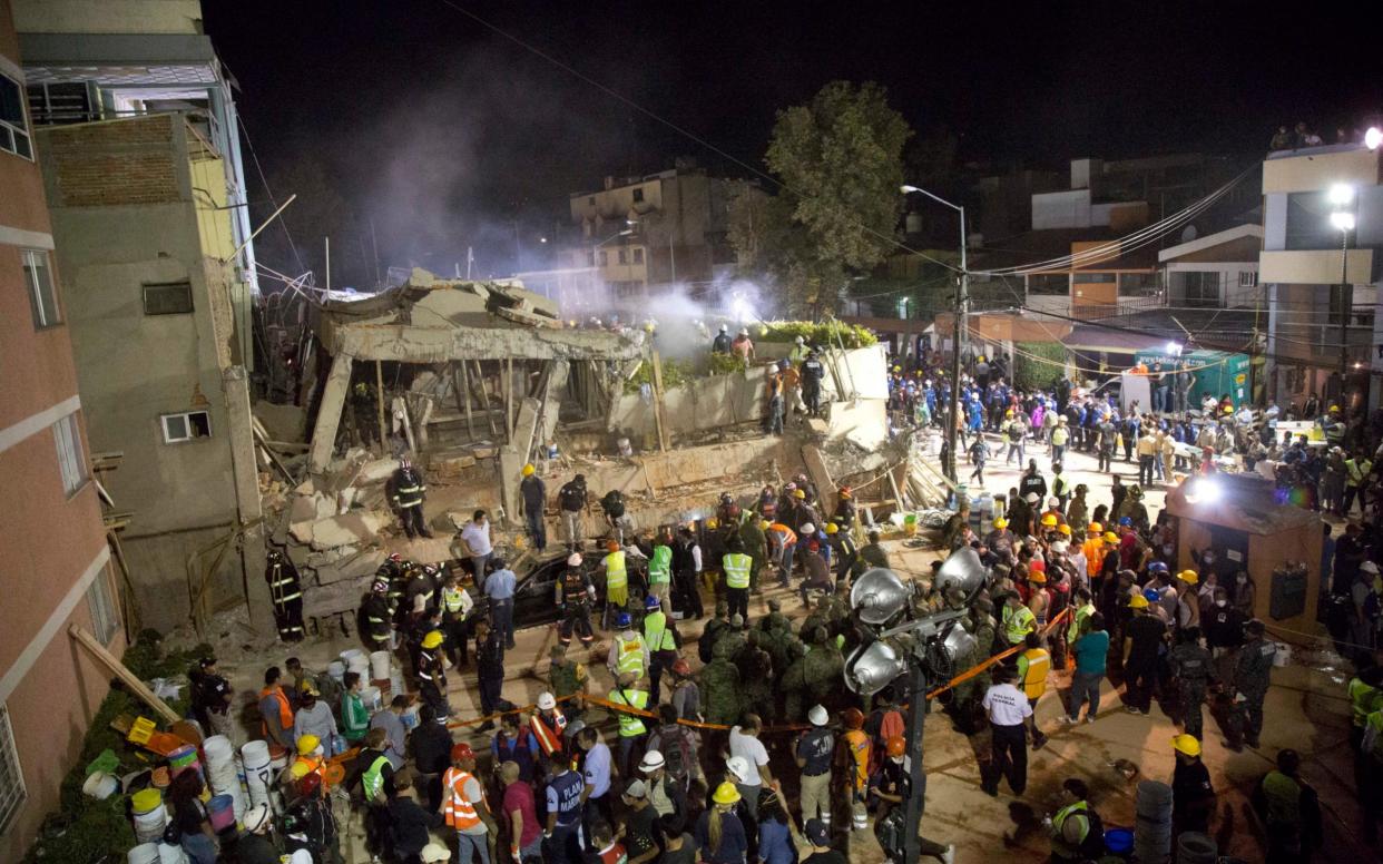 Volunteers and rescue workers search for children trapped inside at the collapsed Enrique Rebsamen school in Mexico City - AP