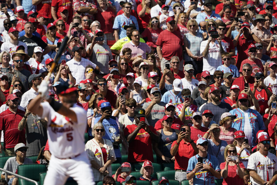 Fans stand and watch as St. Louis Cardinals' Albert Pujols bats during the first inning of a baseball game against the Cincinnati Reds Sunday, Sept. 18, 2022, in St. Louis. (AP Photo/Jeff Roberson)