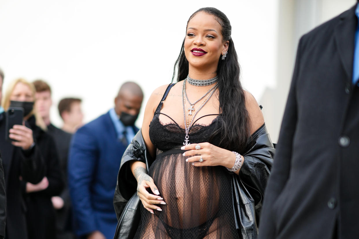 Rihanna showed off her baby bump in lingerie and a sheer dress for the Dior show. (Getty Images)