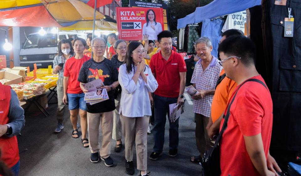 Pakatan harapan Bandar Utama candidate, Jamaliah Jamaluddin (centre) during a walkabout to meet residents at the Kg Cempaka night market. — Picture by Miera Zulyana