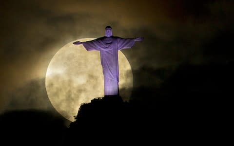 Supermoon is seen behind the Christ the Redeemer statue in Rio de Janeiro, in May 2012. - Credit: AP Photo/Victor R. Caivano