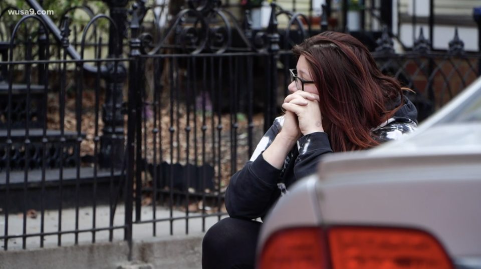 Lauren Handy waits outside as police raid her home in Washington, DC (WUSA9)