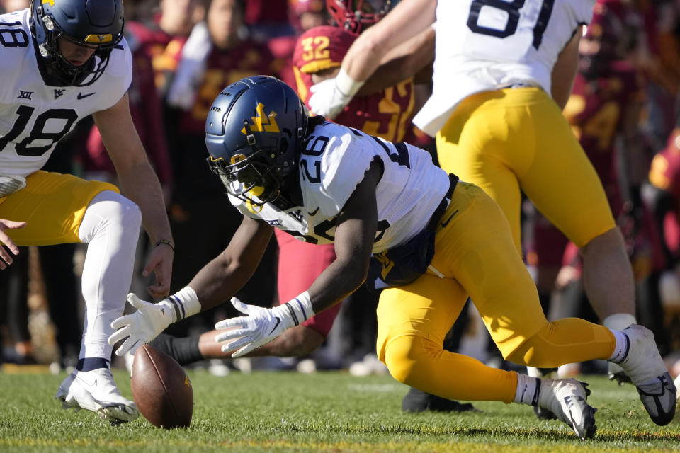 West Virginia running back Justin Johnson Jr. (26) recovers a fumble during the first half of an NCAA college football game against Iowa State, Saturday, Nov. 5, 2022, in Ames, Iowa. (AP Photo/Charlie Neibergall)
