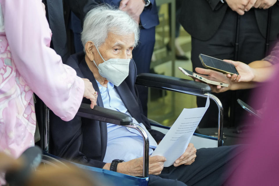 Former Malaysian Finance Minister Daim Zainuddin on wheelchair speaks to media at the courthouse in Kuala Lumpur, Malaysia Monday, Jan. 29, 2024. Daim was charged Monday for failing to declare his assets more than two decades after he left office, in a prosecution he slammed as politically driven. (AP Photo/Vincent Thian)