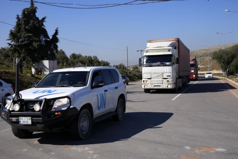 Camiones con ayuda para Siria siguen a un vehículo de la ONU en el paso fronterizo turco de Cilvegozu, en Reyhanli, sureste de Turquía, jueves 9 de febrero de 2023.