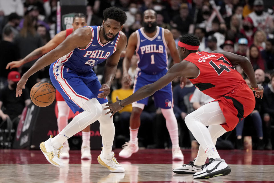 Philadelphia 76ers center Joel Embiid (21) keeps the ball from Toronto Raptors forward Pascal Siakam (43) during the first half of an NBA basketball game Thursday, April 7, 2022, in Toronto. (Frank Gunn/The Canadian Press via AP)