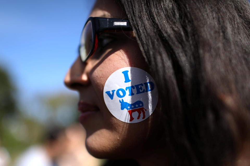 A woman wears a sticker on her face as she listens to U.S. Rep. Beto O'Rourke (D-TX) during the last day of early voting in Texas in Plano