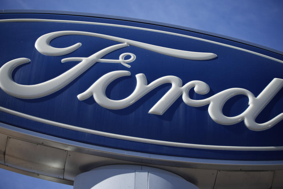 FILE - This Oct. 24, 2021 file photo shows a Ford company logo on a sign at a Ford dealership in southeast Denver. Ford will add 6,200 factory jobs in Michigan, Missouri and Ohio as it prepares to build more electric vehicles and roll out two redesigned combustion-engine models, the company announced, Thursday, June 2, 2022. (AP Photo/David Zalubowski, File)