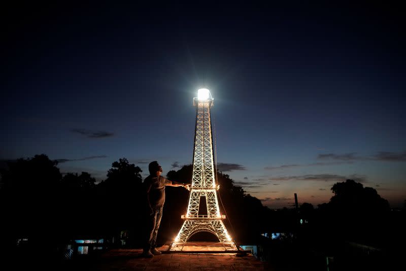 Imagen de Jorge Enrique Salgado posando para una foto junto a la réplica de la Eiffel Tower que construyó en el techo de su casa en La Habana