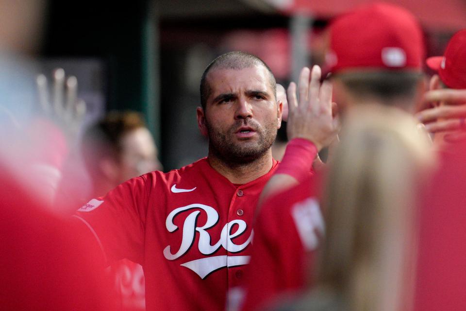 Joey Votto, center, is congratulated after scoring for the Reds against the Cleveland Guardians during the fifth inning in Cincinnati, Wednesday, Aug. 16, 2023.