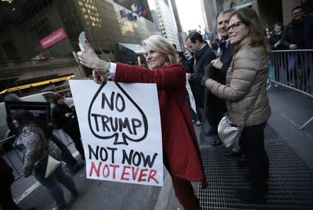 A protester takes a "selfie" while demonstrating against Donald Trump in midtown Manhattan in New York City April 14, 2016. REUTERS/Mike Segar