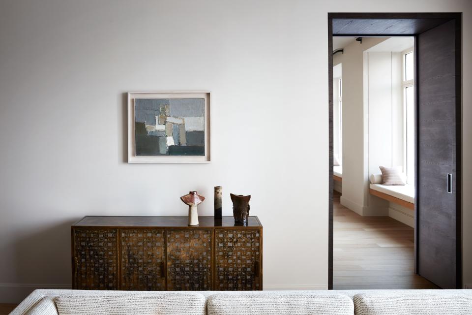 Behind the living room’s sofa, we see the enfilade (a series of interconnected rooms) created by the designer when he overhauled the layout of the apartment. The metal cabinet is a 1950s piece by Philip and Kelvin LaVerne, bought at auction at Phillips. On top are three vintage ceramics from Galeria Bessa Pereira.