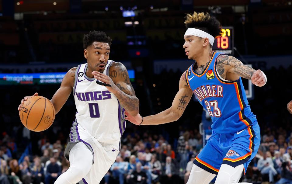 Feb 26, 2023; Oklahoma City, Oklahoma, USA; Sacramento Kings guard Malik Monk (0) drives to the basket against Oklahoma City Thunder guard Tre Mann (23) during the second quarter at Paycom Center. Mandatory Credit: Alonzo Adams-USA TODAY Sports