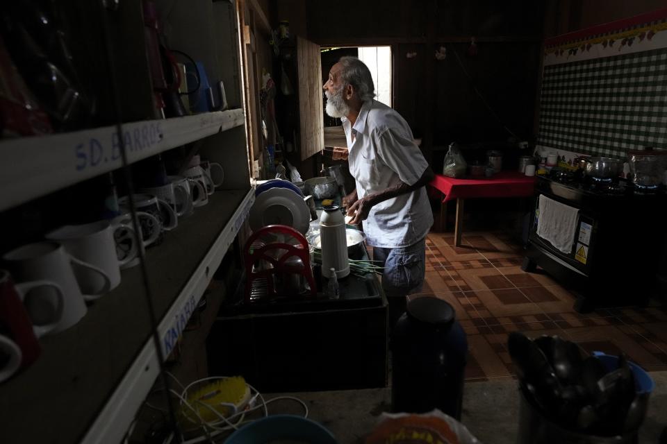 Rubber-tapper Raimundo Mendes de Barros, cousin of legendary rubber tapper leader and environmentalist Chico Mendes, looks out from the kitchen of his house in the Chico Mendes Extractive Reserve, in Xapuri, Acre state, Brazil, Wednesday, Dec. 7, 2022. Thanks to the rubber tappers movement, he said, people now have roads and electricity, and walk around on an equal footing with city residents. (AP Photo/Eraldo Peres)