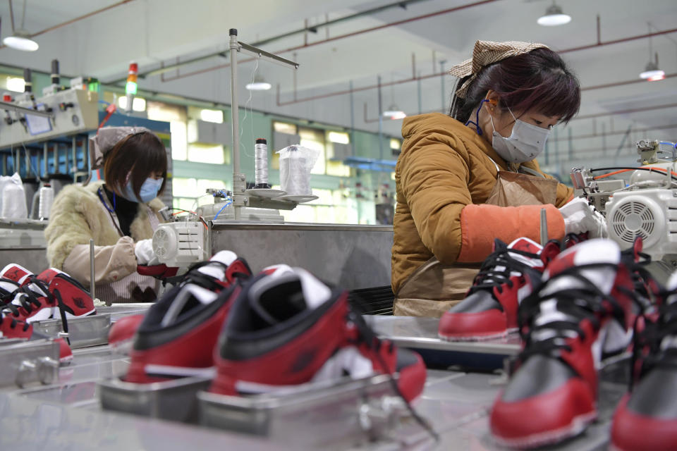 In this photo taken on Feb. 22, 2020 and released by Xinhua News Agency, workers wear mask as they manufacture shoes at a factory in the town of Xiangtang, Nanchang county in eastern China's Jiangxi Province. Factories in China that make the world's smartphones, toys and other consumer goods are trying to protect their employees from a virus outbreak as they resume production. Manufacturers are buying masks by the thousands and jugs of disinfectant. The ruling Communist Party has told local officials to help reopen factories that were idled by the most intensive anti-disease controls ever imposed. (Peng Zhaozhi/Xinhua via AP)