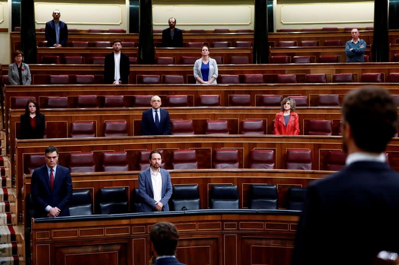 Spanish PM Sanchez and deputies stand up during a minute of silence at the start of a session on coronavirus disease (COVID-19) at Parliament in Madrid