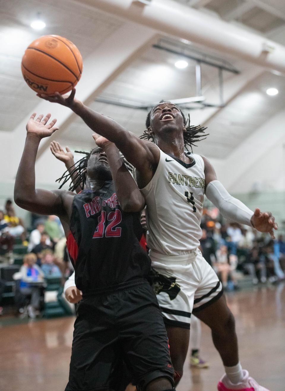 Treymar Jones (4) shoots over Marlin Williams (32) during the Pine Forest vs Milton high school basketball game in the Esca-Rosa Challenge at Pensacola Catholic High School on Tuesday, Nov. 21, 2023.