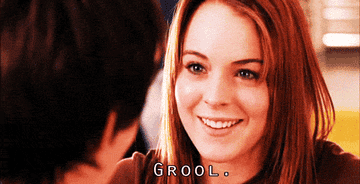 Character Lindsay Lohan in "Mean Girls" smiles awkwardly, overlaid text reads "GROOL."