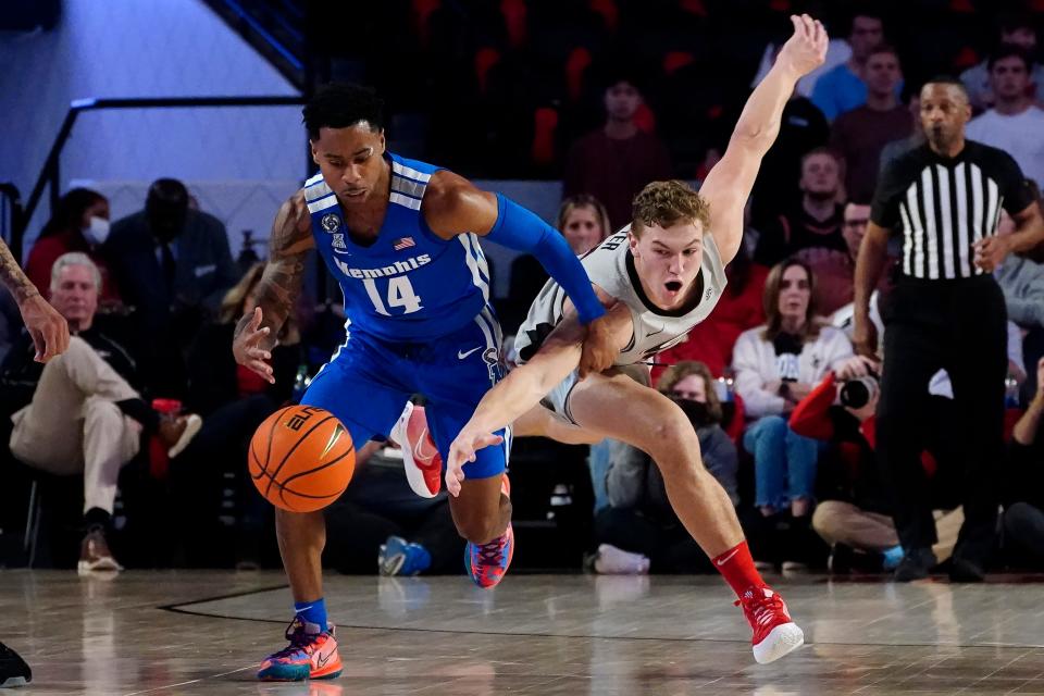 Memphis guard Tyler Harris (14) and Georgia forward Jaxon Etter (11) chase a loose ball during the first half of an NCAA college basketball game Wednesday, Dec. 1, 2021, in Athens, Ga. (AP Photo/John Bazemore)