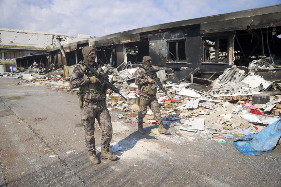 Turkish army soldiers patrol near destroyed buildings in Antakya, southeastern Turkey, Tuesday, Feb. 21, 2023. The death toll in Turkey and Syria rose to eight in a new and powerful earthquake that struck two weeks after a devastating temblor killed nearly 45,000 people, authorities and media said Tuesday. (AP Photo/Unal Cam)