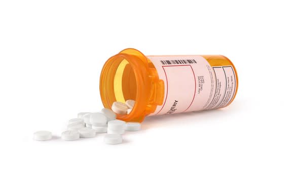 White tablets spilling from a prescription bottle.