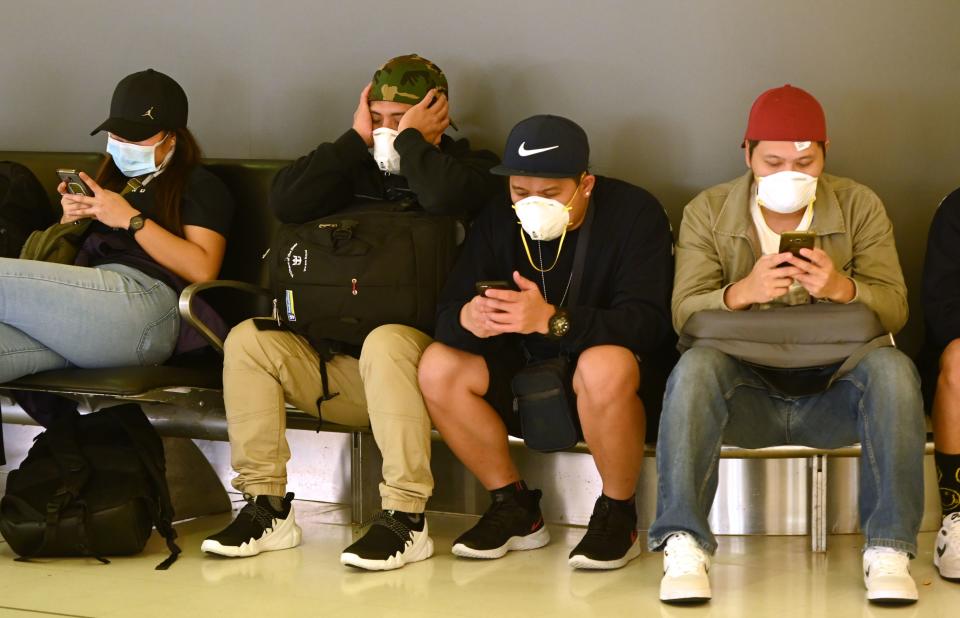 Passengers wait to check-in at the departures hall at the international airport in Sydney on March 18, 2020. - Australia urged its citizens on March 18, not to travel abroad and warned those already overseas to rush home as it imposed unprecedented steps to choke off the spread of the coronavirus epidemic taking off Down Under. (Photo by PETER PARKS / AFP) (Photo by PETER PARKS/AFP via Getty Images)