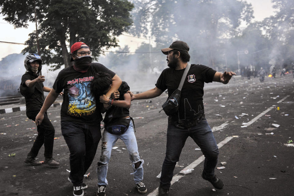 Plain-clothed police officers detain a student protester during a clash in Bandung, West Java, Indonesia, Thursday, Oct. 8, 2020. Thousands of enraged students and workers staged rallies across Indonesia on Thursday in opposition to the new law they say will cripple labor rights and harm the environment. (AP Photo/Bukbis Bey)