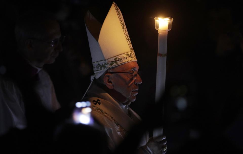 Pope Francis presides over a solemn Easter vigil ceremony in St. Peter's Basilica at the Vatican, Saturday, April 15, 2017. Holding a single candle, Francis processed down the center aisle of a darkened St. Peter's Basilica, symbolizing the darkness that fell after Jesus' crucifixion on Good Friday. (AP Photo/Andrew Medichini)