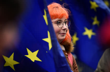 A protester stands among European Union flags outside the Houses of Parliament, after Prime Minister Theresa May's Brexit deal was rejected, in London, Britain, January 16, 2019. REUTERS/Clodagh Kilcoyne