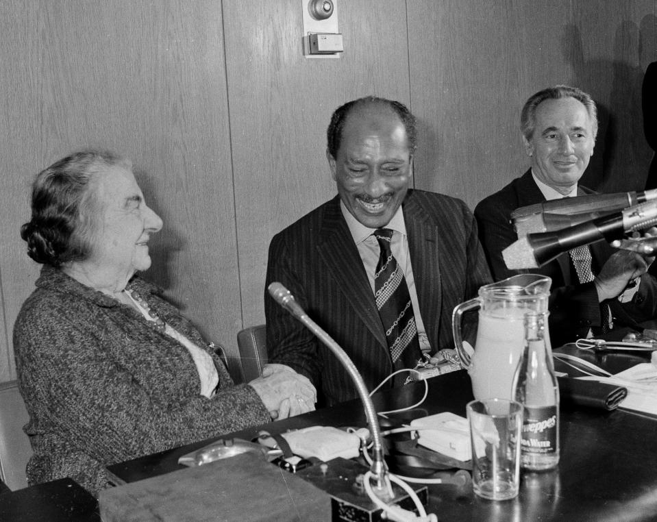 <p>Egyptian President Anwar Sadat, center, shakes hands with former Israeli Prime Minister Golda Meir in the Knesset building, Jerusalem, Nov. 21, 1977, where they met for final political talks. At right is Shimon Peres, leader of the Israeli Labor Party. (AP Photo) </p>