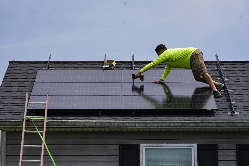 Nicholas Hartnett, owner of Pure Power Solar, secures solar panel on the roof of a home in Frankfort, Ky., Monday, July 17, 2023. Since passage of the Inflation Reduction Act, it has boosted the U.S. transition to renewable energy, accelerated green domestic manufacturing, and made it more affordable for consumers to make climate-friendly purchases, such as installing solar panels on their roofs. (AP Photo/Michael Conroy)