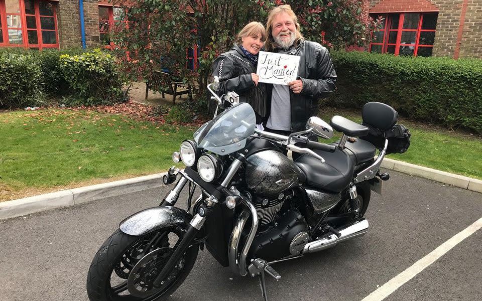 Tina and Mick Hickman pose with 'Just Married' sign behind motorcycle - Dorset County Hospital NHS Foundation Trust Facebook page