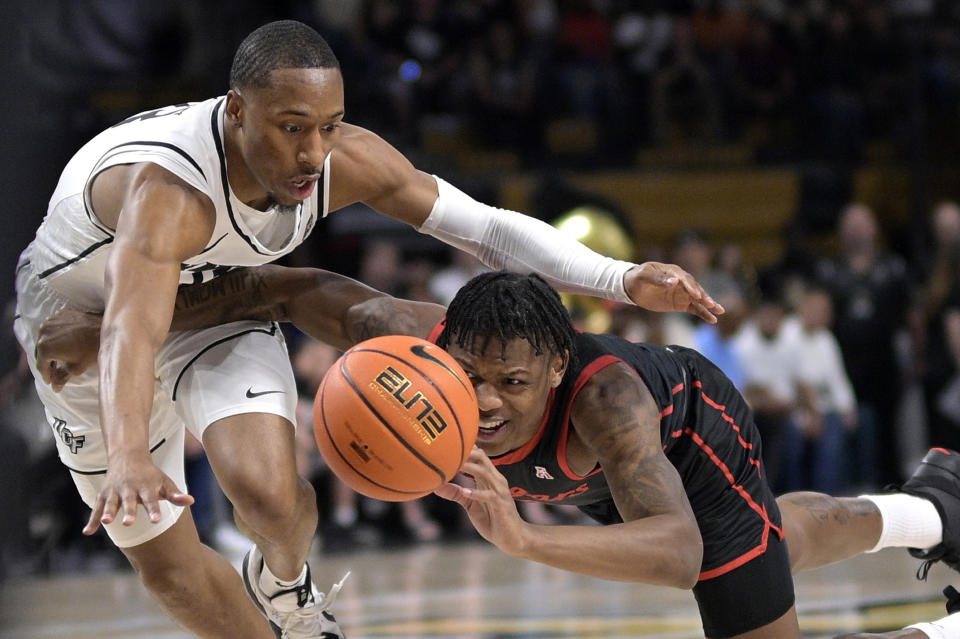 Central Florida guard C.J. Kelly, left, and Houston guard Marcus Sasser scramble for a loose ball during the first half of an NCAA college basketball game, Wednesday, Jan. 25, 2023, in Orlando, Fla. (AP Photo/Phelan M. Ebenhack)