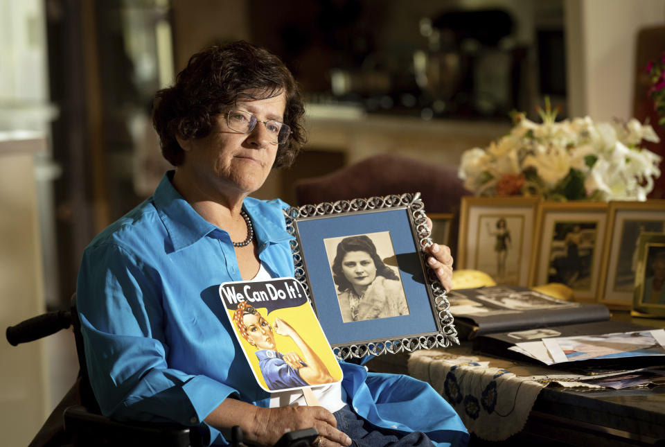 Dorene Giacopini holds up a photo of her mother Primetta Giacopini while posing for a photo at her home in Richmond, Calif. on Monday, Sept. 27, 2021. Primetta Giacopini's life ended the way it began — in a pandemic. She was two years old when she lost her mother to the Spanish flu in Connecticut in 1918. Giacopini contracted COVID-19 earlier this month. The 105-year-old struggled with the disease for a week before she died Sept. 16. (AP Photo/Josh Edelson)