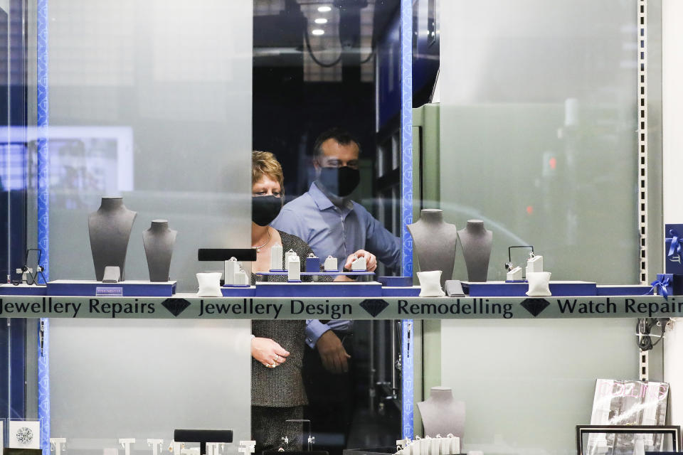 A jeweler prepares a shop front window in Melbourne, Australia, Wednesday, Oct. 28, 2020. Australia’s second largest city of Melbourne which was a coronavirus hotspot emerges from a nearly four-months lockdown, with restaurants, cafes and bars opening and outdoor contact sports resuming on Wednesday. (AP Photo/Asanka Brendon Ratnayake)