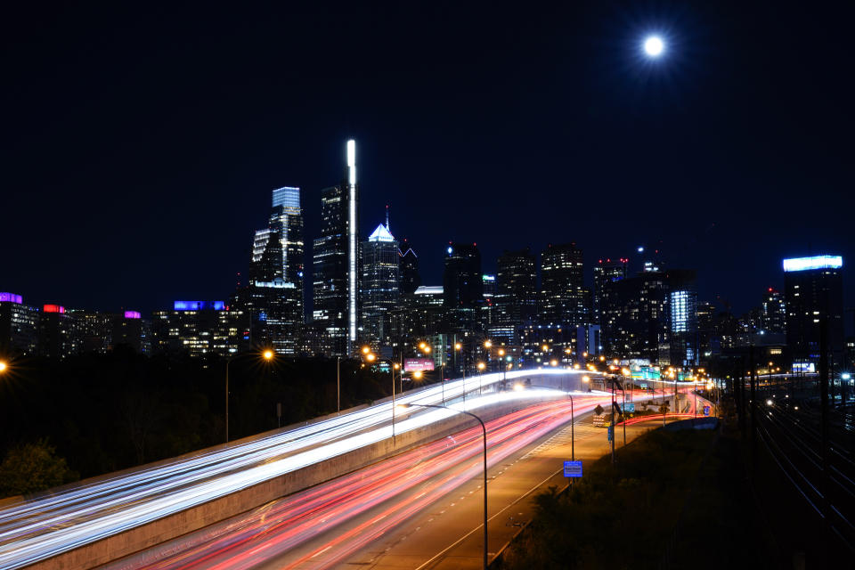 FILE - In this June 23, 2021, file slow-shutter speed exposure photo, the moon rises over the Philadelphia and Interstate 76. Senators working on the infrastructure plan hope to have a bill ready to be voted on next week. President Joe Biden has made passing the bipartisan plan a top priority, the first of his two-part $4 trillion proposal to rebuild, but a Senate test vote failed this week after Republicans said they needed more time to finish the package and review the details. (AP Photo/Matt Rourke, File)