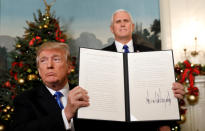 <p>Vice President Mike Pence stands behind as President Donald Trump holds up the proclamation he signed that the United States recognizes Jerusalem as the capital of Israel and will move its embassy there, during an address from the White House in Washington, Dec. 6, 2017. (Photo: Kevin Lamarque/Reuters) </p>