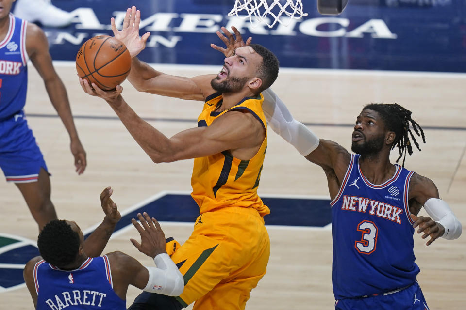 Utah Jazz center Rudy Gobert, center lays the ball up as New York Knicks' RJ Barrett, left, and Nerlens Noel (3) defend in the second half during an NBA basketball game Tuesday, Jan. 26, 2021, in Salt Lake City. (AP Photo/Rick Bowmer)