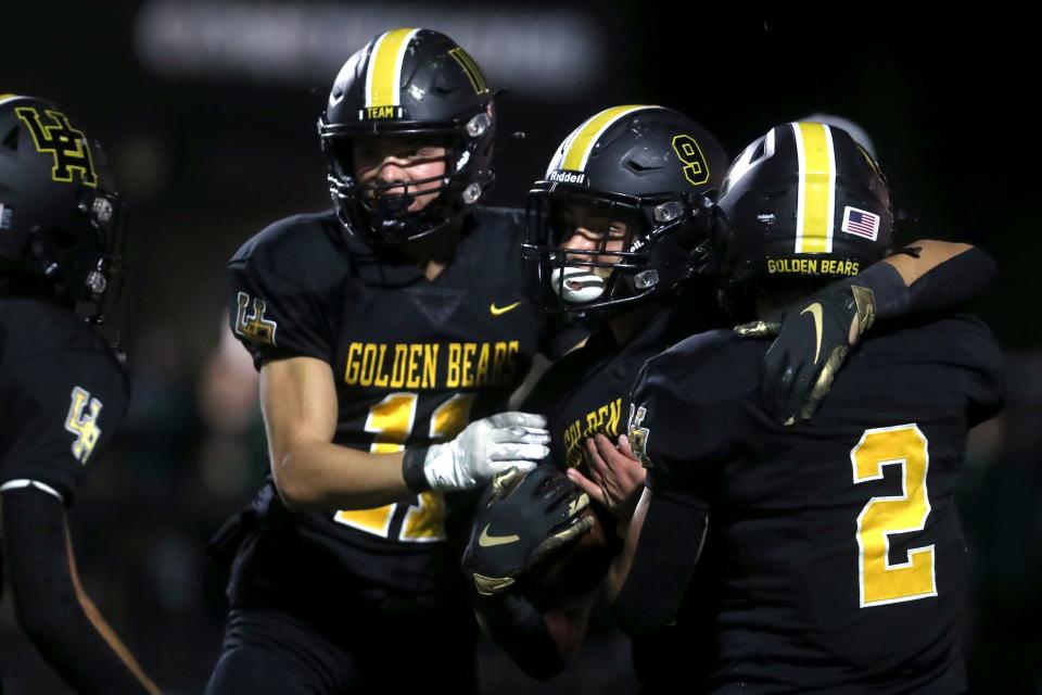 Upper Arlington's Caden Woods (11), Rocco Prati (9) and Jack Ubert (2) celebrate after Prati's touchdown reception against Dublin Coffman on Oct. 14 at Upper Arlington High School.