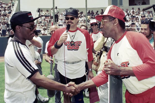 <p>Bob Riha, Jr./Getty</p> Eddie Murphy and Bill Cosby shake hands at a celebrity softball game at Loyola Marymount University on June 11, 1989, in Los Angeles