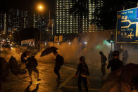 In this Oct. 6, 2019, photo, protestors face police tear gas in Hong Kong. Shouting "Wearing mask is not a crime," tens of thousands of protesters braved the rain Sunday to march in central Hong Kong as a court rejected a second legal attempt to block a mask ban aimed at quashing violence during four months of pro-democracy rallies. (AP Photo/Felipe Dana, File)