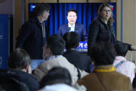 People watch a TV screen showing the live broadcast of South Korean President Yoon Suk Yeol’s addressing the nation at the Seoul Railway Station in Seoul, South Korea, Monday, April 1, 2024. President Yoon vowed Monday not to back down in the face of vehement protests by doctors seeking to spike his plan to drastically increase medical school admissions, as he called their walkouts “an illegal collective action” that poses "a grave threat to our society.” (AP Photo/Ahn Young-joon)